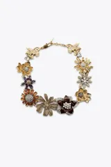 Collar dorado con dije de flores metálicas con brillos y joyas de diferentes colores.