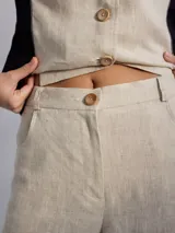 Pantalón ancho de corte recto con fit holgado, de lino color beige con bloques de color negro y marrón.