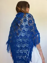 Chal azul tejido a crochet con diseño calado y flecos.