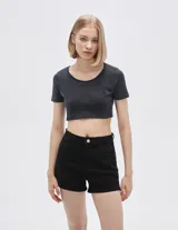 Top cropped negro de poliamida con cuello redondo y mangas cortas. Diseño ajustado al cuerpo.