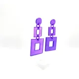 Caravanas compuestas por piezas cuadradas de resina en color violeta, con ajuste por perforación y libre de níquel.