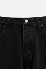 Pantalón de jean negro de corte amplio, estilo balloon fit, con cinco bolsillos, efecto lavado y cierre frontal con botones.