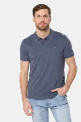 Chomba azul de jersey de algodón con cuello polo y tapeta de dos botones. Tiene mangas cortas con puños acanalados y logo bordado en el pecho.