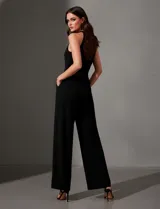 Enterito largo de crepe color rojo, con escote halter anudado y pierna ancha. Presenta bolsillos delanteros y abertura en la espalda con cierre invisible y botón.