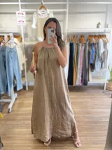 Vestido largo de lino color crudo, con escote halter fruncido y abertura lateral en la falda.