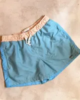 Short de baño celeste con cintura elastizada color durazno y cordón ajustable.