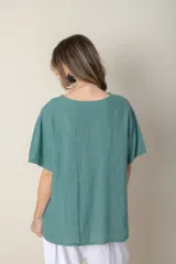 Blusa italiana color crudo de lino con escote en V y mangas cortas. Presenta detalle de bordado calado en el canesú.