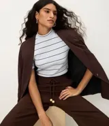 Blusa de ribana color beige con rayas horizontales negras, cuello medio y mangas cortas.