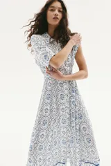 Vestido midi con estampado floral en tonos celeste y azul, cuello camisero, botonadura frontal, mangas cortas raglán, elástico en la cintura y cinturón extraíble para atar.