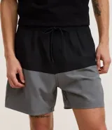 Bermuda de baño masculina confeccionada en microfibra, con cintura elástica, cordón ajustable, bolsillos laterales y trasero con cremallera, y estampado bicolor.