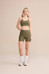 Short deportivo verde militar, ajustado al cuerpo, con bolsillos laterales y cintura alta.