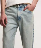 Pantalón masculino de jean con lavado dirty, modelo loose, cintura con trabilla y bolsillos.