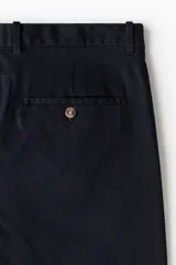 Pantalón de vestir negro de corte slim fit, con bolsillos laterales y traseros.