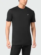 Camiseta negra de manga corta con cuello redondo y un pequeño aplique hexagonal con logo en el pecho izquierdo.