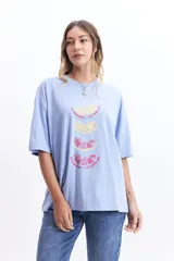 Remera celeste de corte amplio con estampado de rodajas de cítricos.