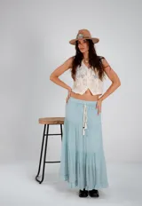 Pollera larga de color celeste con volados y cintura elastizada con cordón.