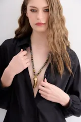 Collar de inspiración étnica con piezas circulares de madera pintada y un dije central de cuerno metálico.