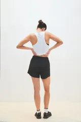 Musculosa deportiva blanca con logo pequeño en el pecho.