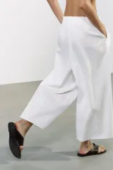 Pantalón culotte negro de tiro medio con cintura elástica y bolsillos laterales ocultos en la costura.