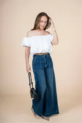 Blusa blanca con escote elástico que permite usarla con hombros descubiertos o más alta.