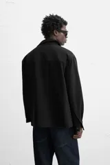 Sobrecamisa color beige de corte relaxed fit, con cuello solapa, manga larga con puños abotonados, bolsillos de plastrón con solapa en el pecho y bolsillos de vivo en la cadera. Cierre frontal con botones.