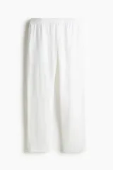 Pantalón blanco de lino liviano, corte recto, con elástico revestido y cordón ajustable en la cintura, bolsillos laterales y bolsillo trasero insertado.