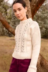 Sweater tejido color crudo con cuello redondo y mangas largas. Presenta detalles de ochos en el frente y está confeccionado artesanalmente en Uruguay.