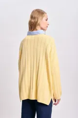 Sweater de punto tejido color amarillo, de corte holgado y cuello alto.