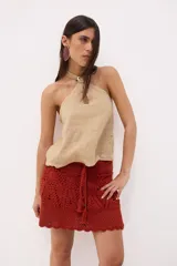 Top de lino color azul con escote halter cruzado y detalle de hebilla metálica cuadrada en el cuello. Presenta una pequeña abertura frontal tipo gota y un diseño de calce relajado.