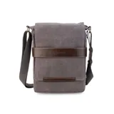 Matera de canvas color negro, combinada con símil cuero marrón. Cuenta con tapa, broches magnéticos, bolsillo tipo guantera bajo la tapa, división interna con velcro para usar como morral y bolsillo trasero con broche magnético. Incluye correa larga regulable.