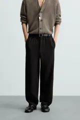 Pantalón de vestir color blanco hueso, de corte recto y tiro medio, con cintura elástica y cierre frontal de botón y cremallera. Presenta bolsillos frontales y bolsillos traseros de vivo.