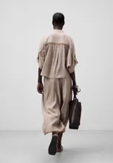 Pantalón cropped color beige de lino europeo y viscosa responsable, con trabillas, bolsillos laterales y traseros, pierna ancha y bajo desflecado.