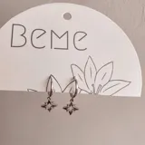Aros plateados con diseño de estrellas y cierre tipo aro.