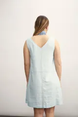 Vestido corto color negro, sin mangas, con escote en V y bolsillos laterales.