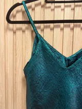 Top metalizado color verde esmeralda, de breteles finos y corte clásico.