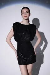 Minivestido negro de lentejuelas con corte ajustado y mangas cortas.