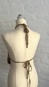 Top con estampado abstracto en tonos marrones y blancos, con tiras para atar en el cuello y la espalda.