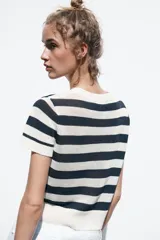 Top de punto celeste con rayas horizontales en azul. Tiene cuello redondo y mangas cortas.