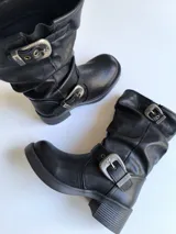 Bota corta negra de cuero con hebillas plateadas y taco bajo.