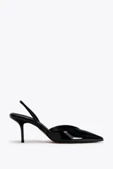 Zapato destalonado de charol negro con escote en pico, tira trasera ajustable y tacón fino.