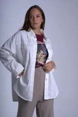 Sobrecamisa negra de gabardina con cuello camisero, cierre frontal con botones, mangas largas con puños abotonados y bolsillos de parche en el pecho.