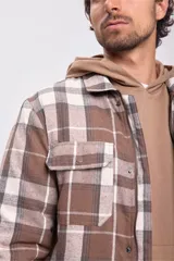 Sobrecamisa de franela a cuadros color tostado, con cierre frontal con botones y bolsillos en el pecho.