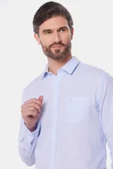 Camisa de lino color beige, de manga larga, con cuello clásico y bolsillo en el pecho.