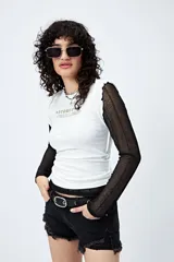 Remera negra con estampa frontal de la palabra 'Fearless' en color blanco. Corte ajustado y terminaciones con volados sutiles.