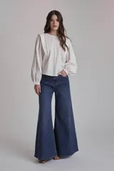 Blusa blanca con cuello redondo y mangas largas abullonadas.
