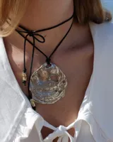 Collar con dije grande de bronce con forma de ostra y cordón de algodón ajustable color gris.