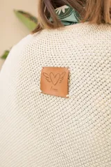 Poncho tejido en hilo de algodón con lurex color negro y dorado, con flecos en el ruedo.