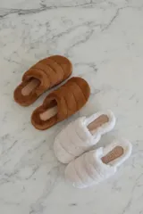 Pantuflas tipo slides forradas en piel sintética color blanco o negro, con base de goma.