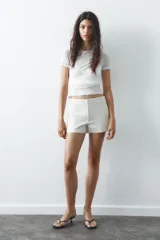 Shorts tiro bajo color negro con bolsillos delanteros. Cierre frontal con cremallera y ganchos metálicos.