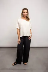 Pantalón negro de tela texturizada, corte ancho y cintura elastizada con cordón ajustable.